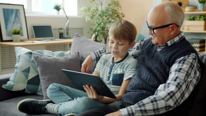 Nagypapa és unokája együtt nézik a tabletet