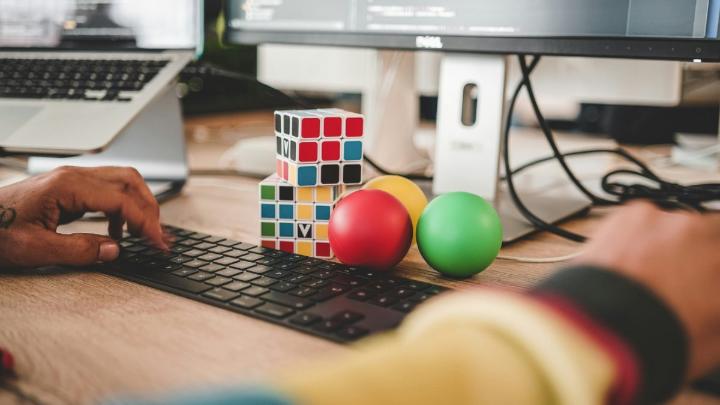 Színes Rubik-kockák a számítógép mellett, digitális készségek diákoknak